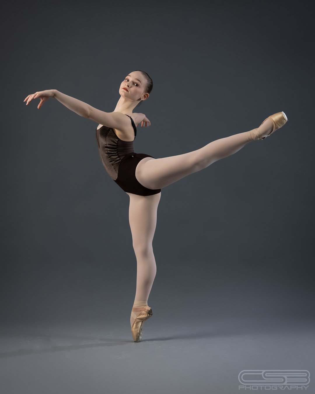 young dancer performs arabesque in studio